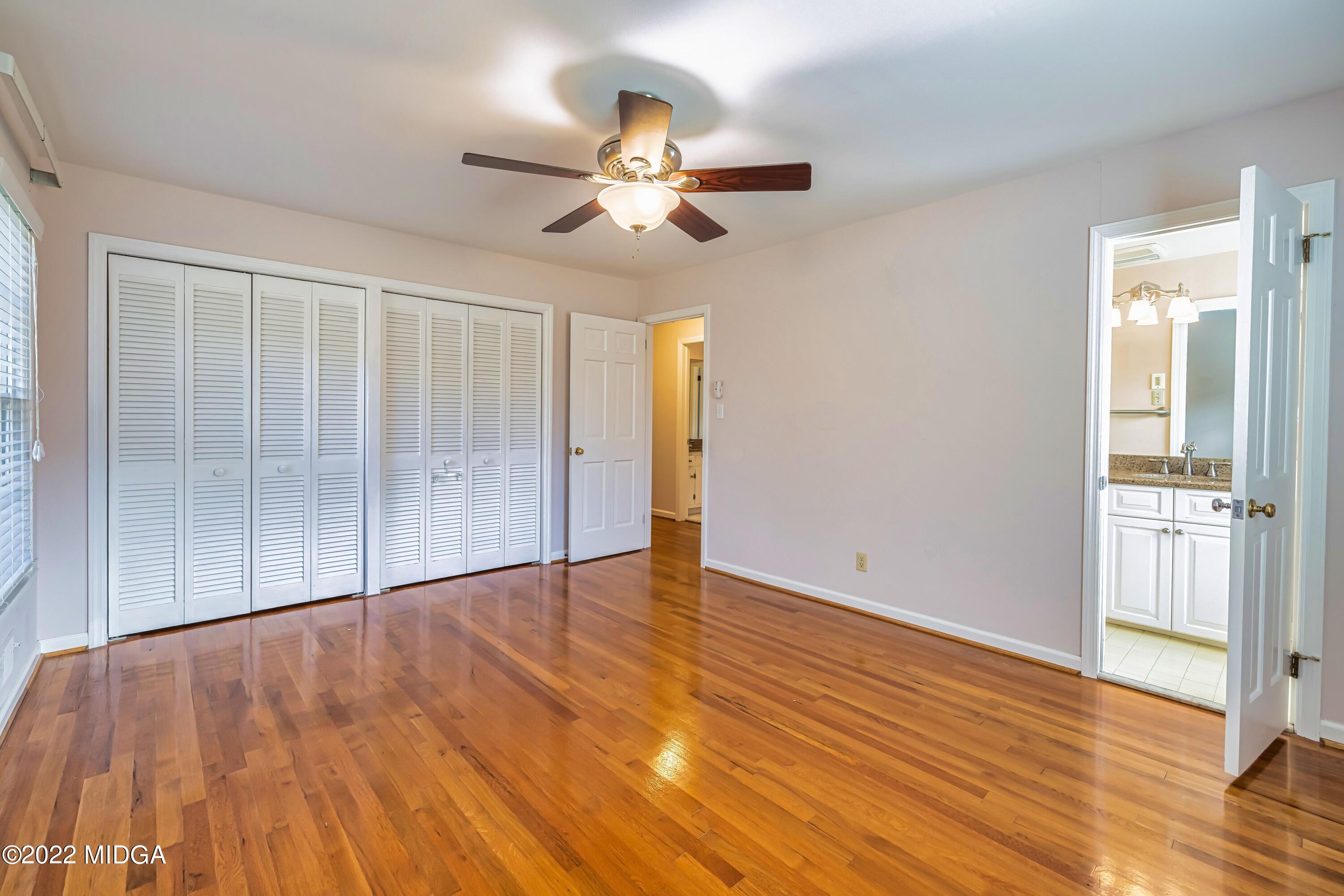 201 Larcom Lane Griffin, GA 30224 - Photo 43 of 64 an empty room with wooden floor chandelier fan and windows