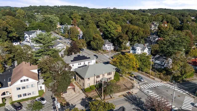 an aerial view of a house with swimming pool and large trees