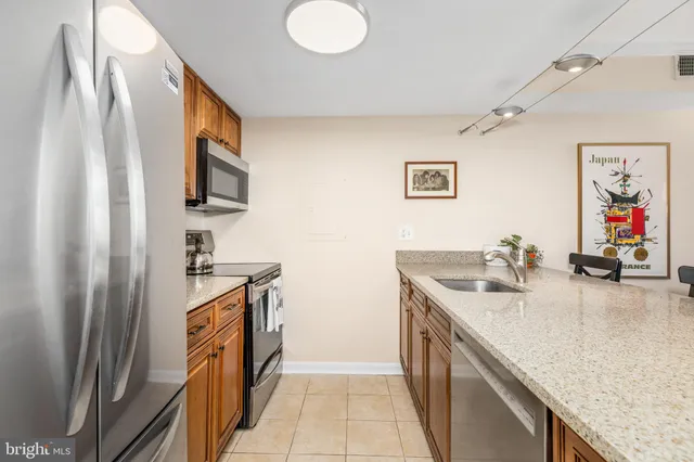 a kitchen with stainless steel appliances granite countertop a sink and a refrigerator