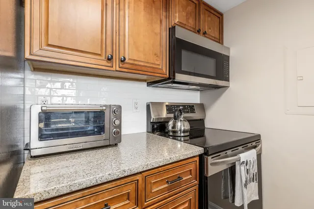 a kitchen with stainless steel appliances granite countertop a stove microwave and oven