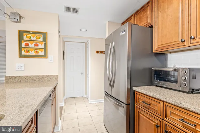 a kitchen with granite countertop a refrigerator and a sink