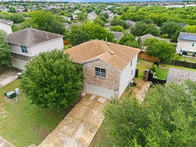 an aerial view of a house with yard and green space