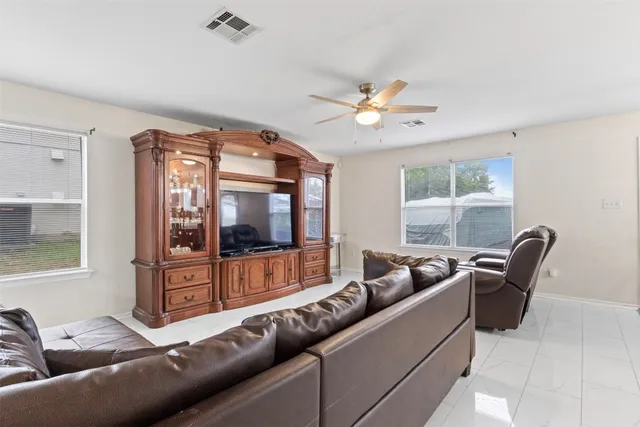 a living room with furniture a ceiling fan and a window