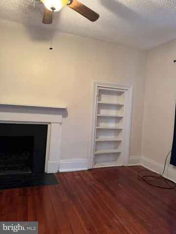 a view of a livingroom with a fireplace and wooden floor