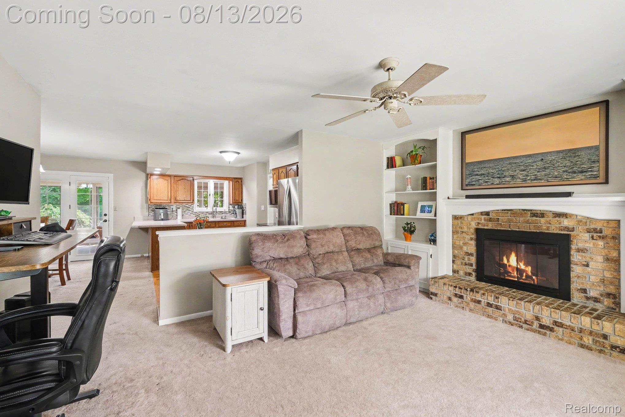 10361 Coldwater Road Flushing, MI 48433 - Photo 4 of 37 Brick fireplace with a white mantel, built-in shelving, and a ceiling fan