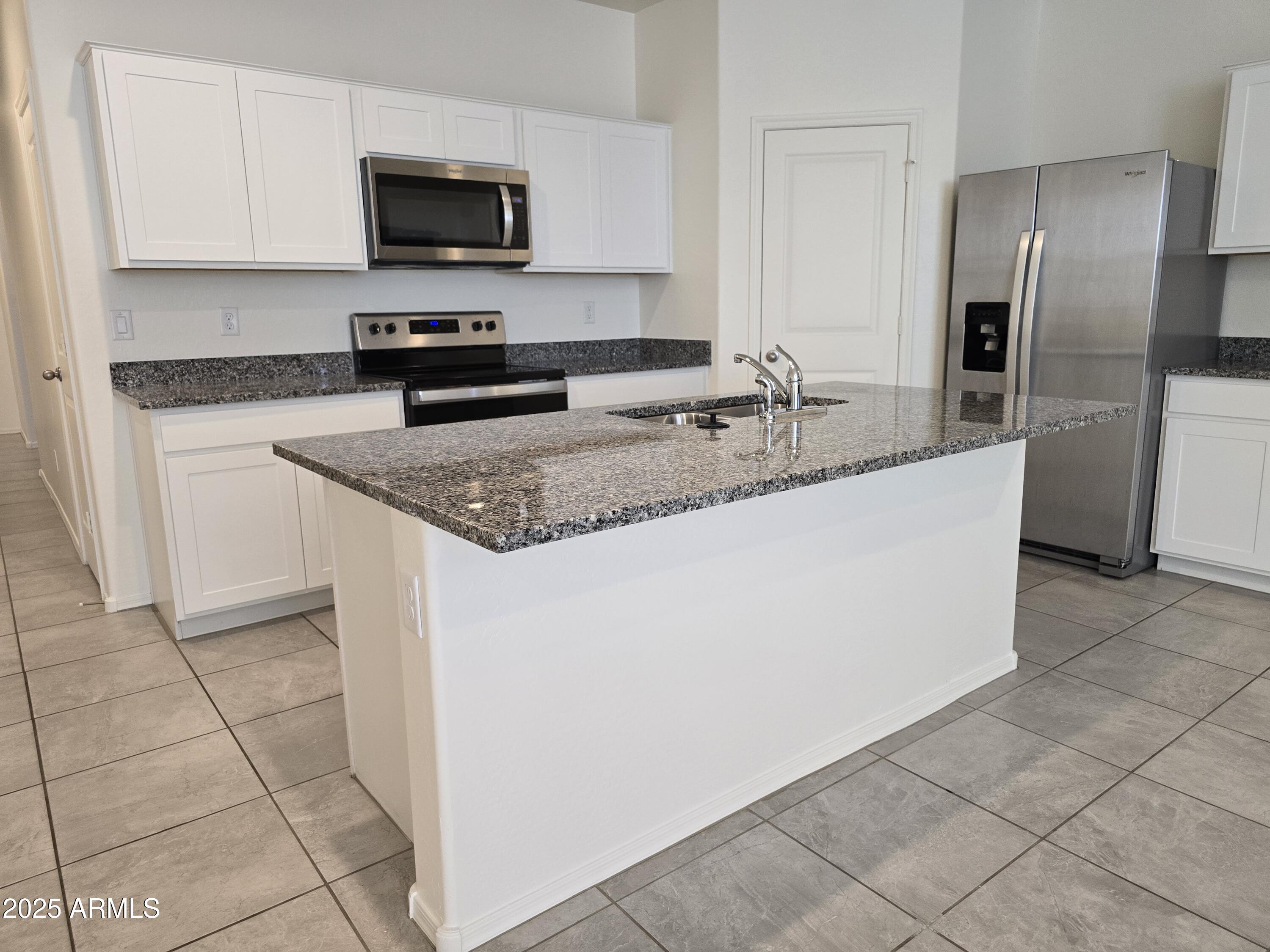 1127 West Sand Canyon Court Casa Grande, AZ 85122 - Photo 3 of 5 a kitchen with stainless steel appliances granite countertop a sink a stove a microwave and a refrigerator