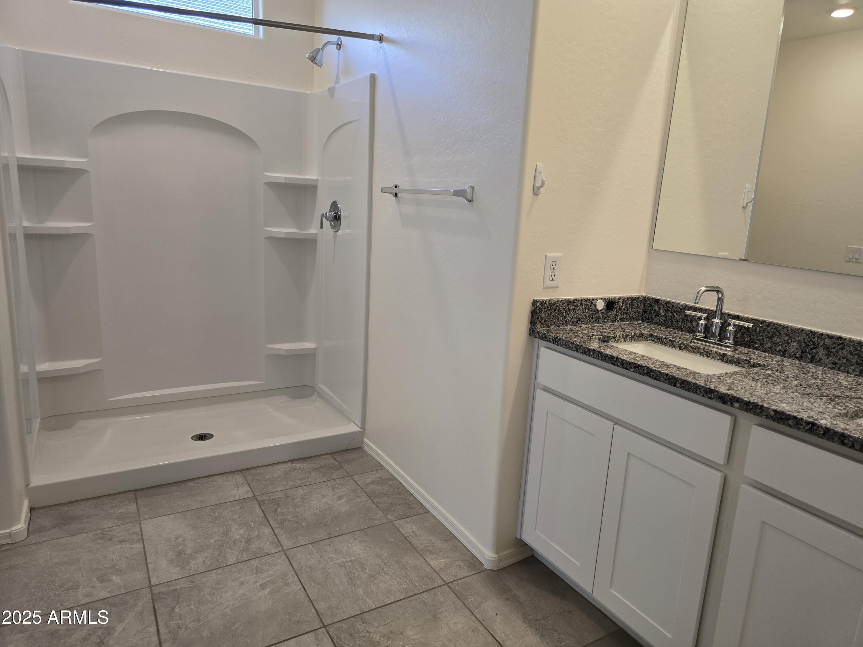 1127 West Sand Canyon Court Casa Grande, AZ 85122 - Photo 5 of 5 a bathroom with a granite countertop sink a mirror and a bathtub