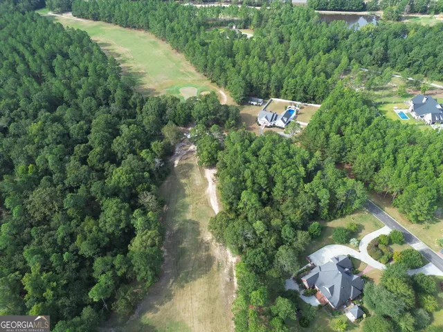 an aerial view of a house with a yard and lake view