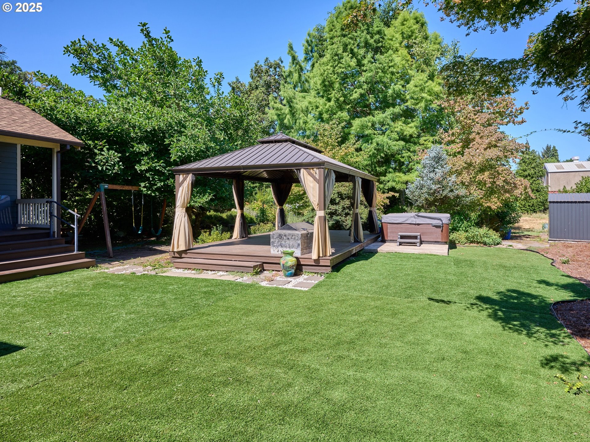 795 Corby Street Woodburn, OR 97071 - Photo 32 of 44 a view of a wooden deck with a bench and trees
