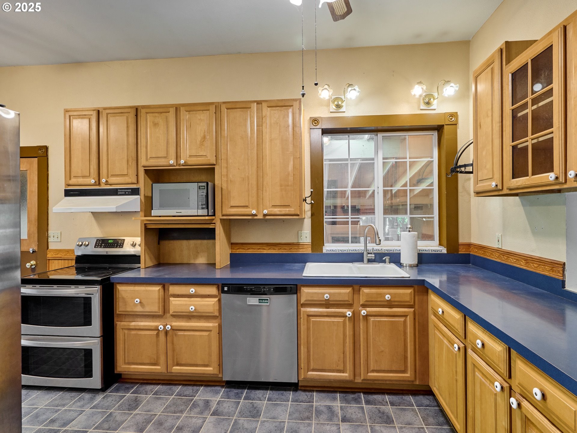 795 Corby Street Woodburn, OR 97071 - Photo 9 of 44 a kitchen with kitchen island granite countertop a stove sink and cabinets