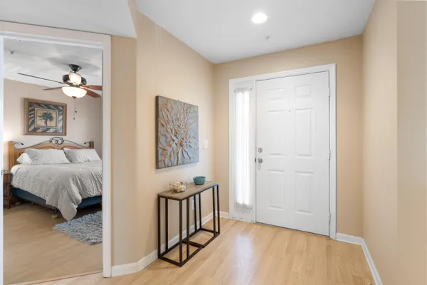 a view of a bedroom with a bed and wooden floor