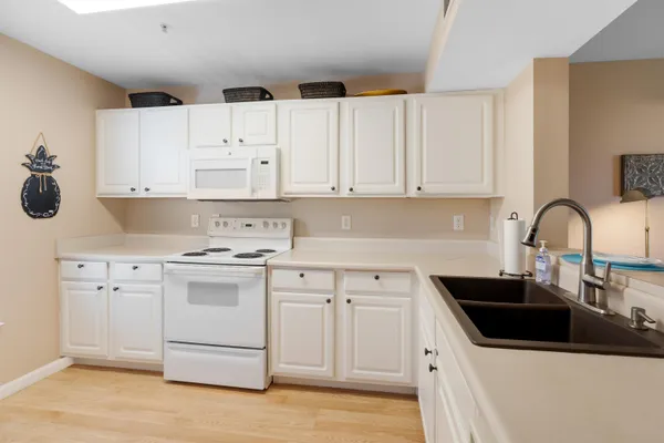 a kitchen with kitchen island a sink a stove and white cabinets