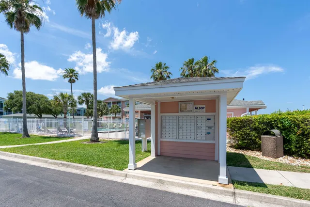 a front view of a house with a yard and potted plants