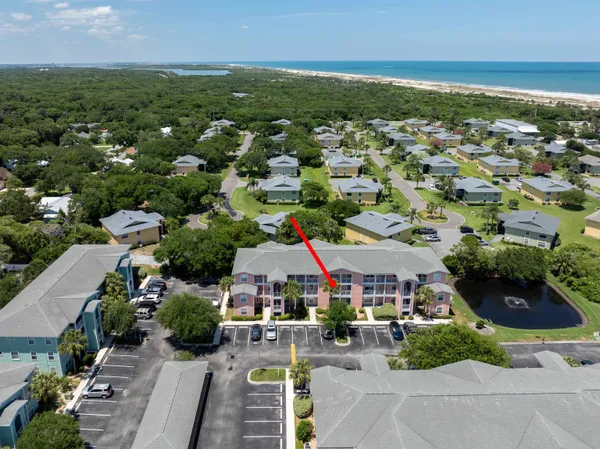 an aerial view of a city with lots of residential buildings ocean and mountain view in back