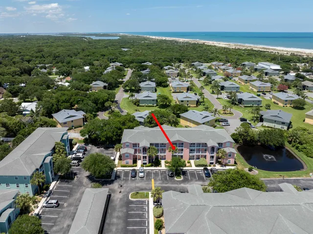 an aerial view of a city with lots of residential buildings ocean and mountain view in back