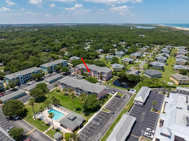 an aerial view of residential houses with outdoor space and trees