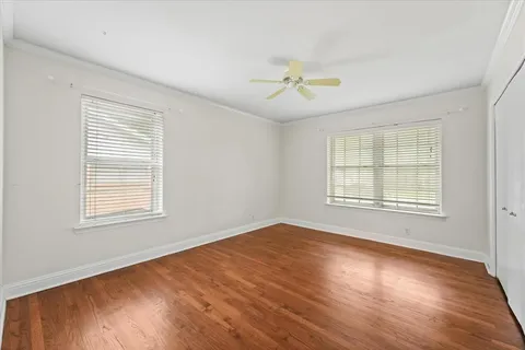 a view of an empty room with a window and wooden floor