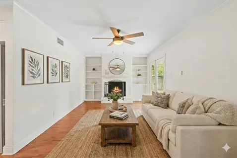 a living room with furniture a fireplace and wooden floor