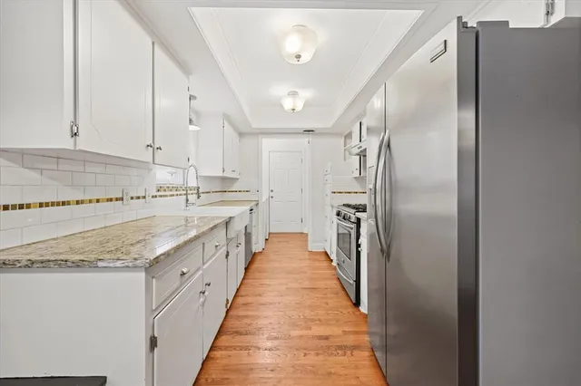 a kitchen with stainless steel appliances granite countertop a refrigerator and a sink