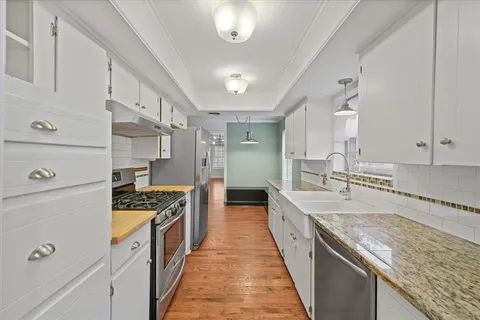 a large kitchen with stainless steel appliances granite countertop a stove and a sink