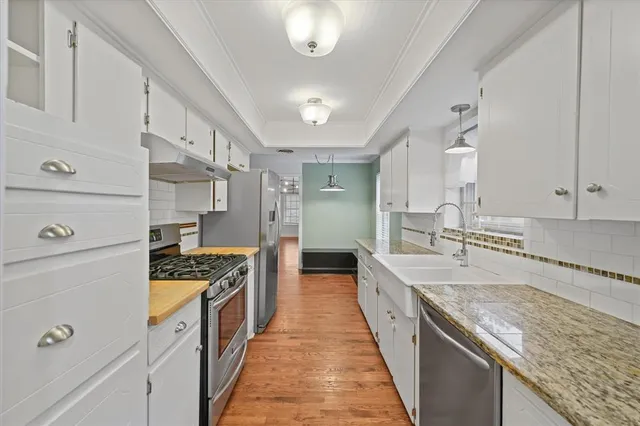 a large kitchen with stainless steel appliances granite countertop a stove and a sink