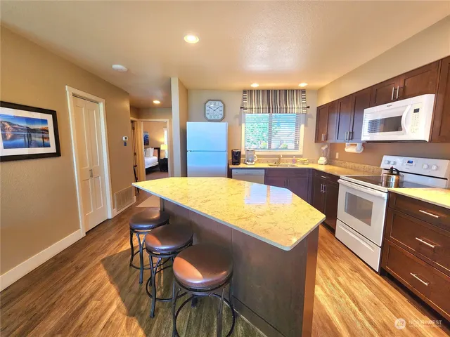 a kitchen with a table chairs and wooden floor