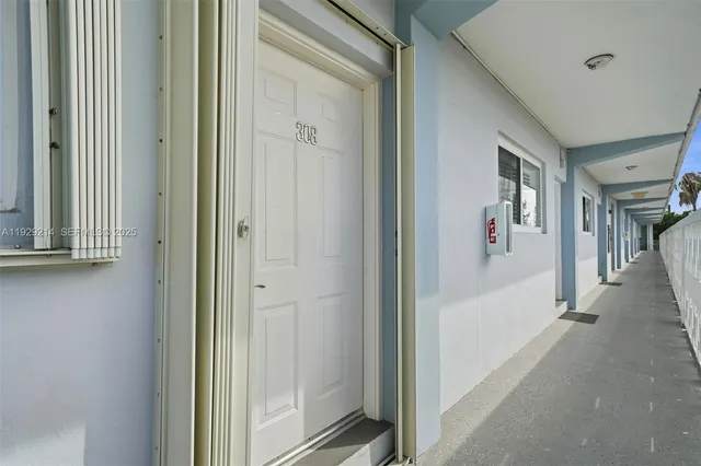 a view of a hallway with wooden floor and a bathroom