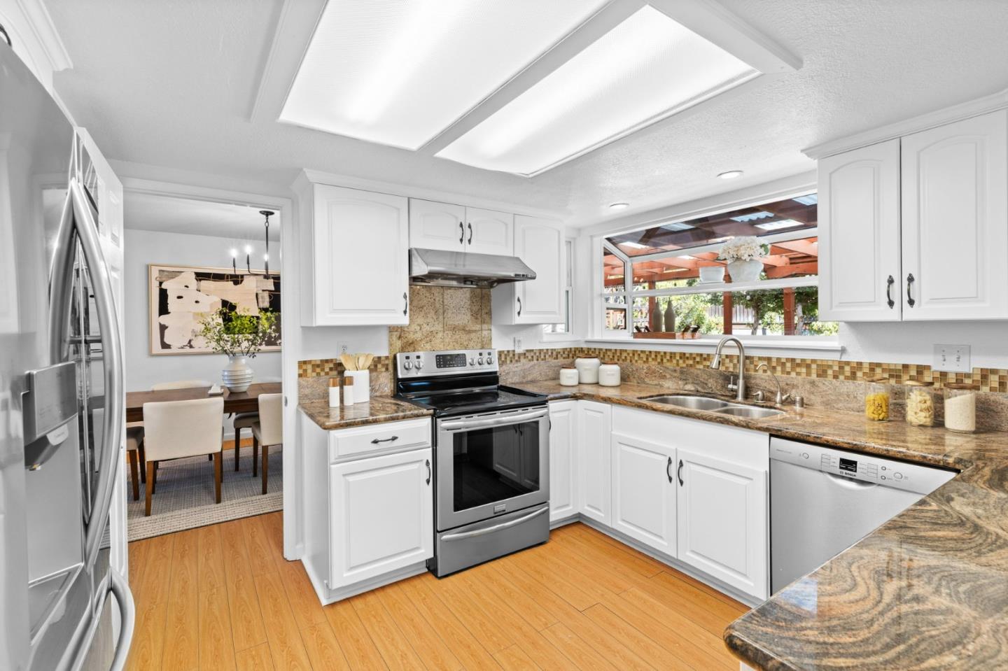 1386 Prada Court Milpitas, CA 95035 - Photo 10 of 36 a kitchen with stainless steel appliances granite countertop a stove and white cabinets