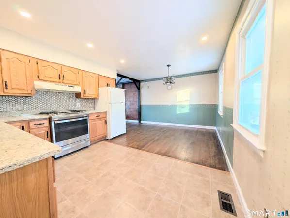 a kitchen with stainless steel appliances a refrigerator and a stove top oven
