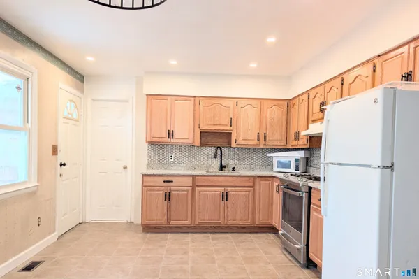 a kitchen with a sink a refrigerator and a stove top oven