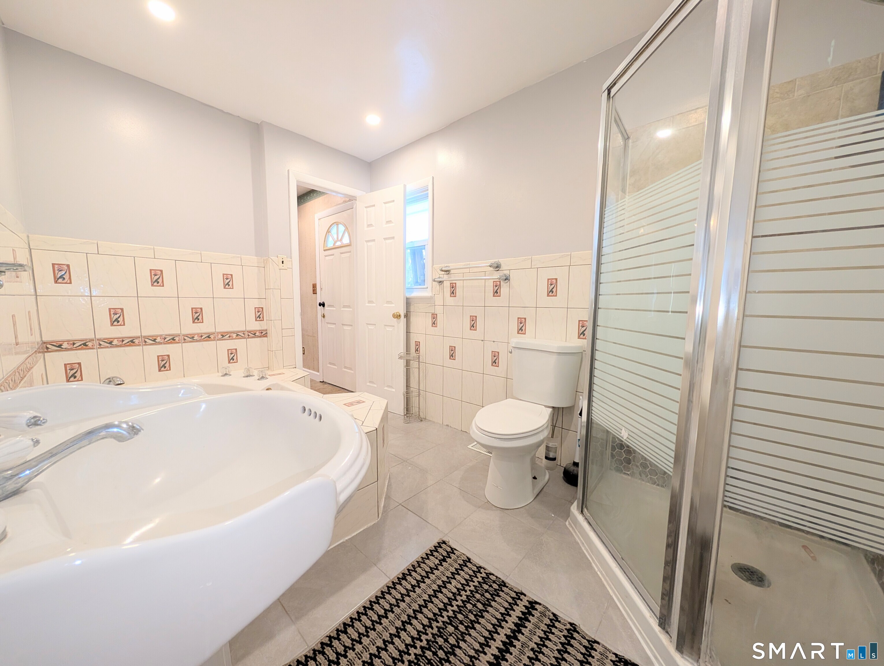 139 Little Deer Road Bridgeport, CT 06606 - Photo 18 of 35 a spacious bathroom with a bathtub shower sink mirror and toilet