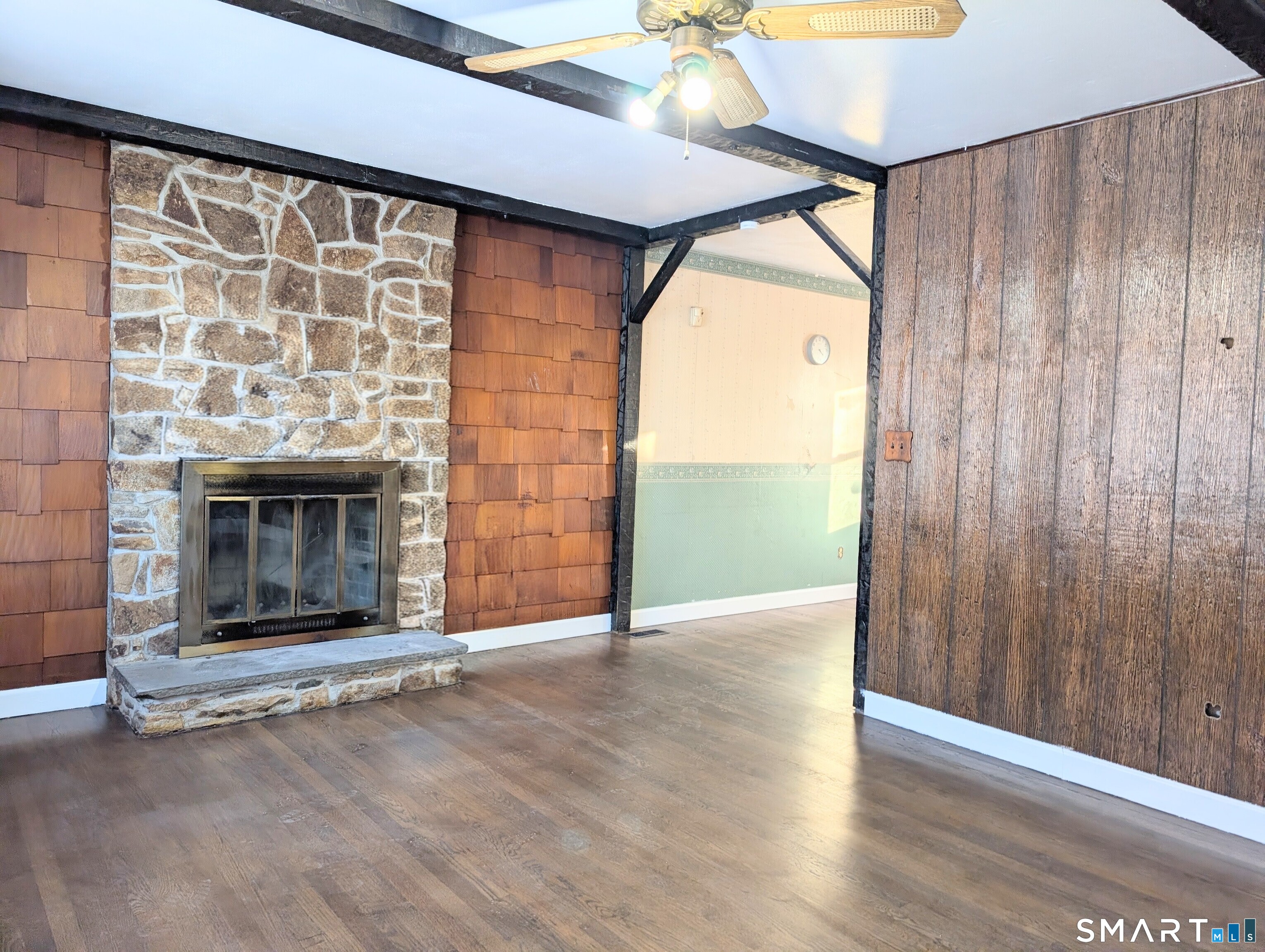 139 Little Deer Road Bridgeport, CT 06606 - Photo 6 of 35 an empty room with wooden floor fireplace and window