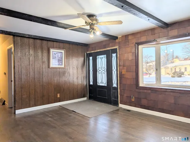 an empty room with windows and fan