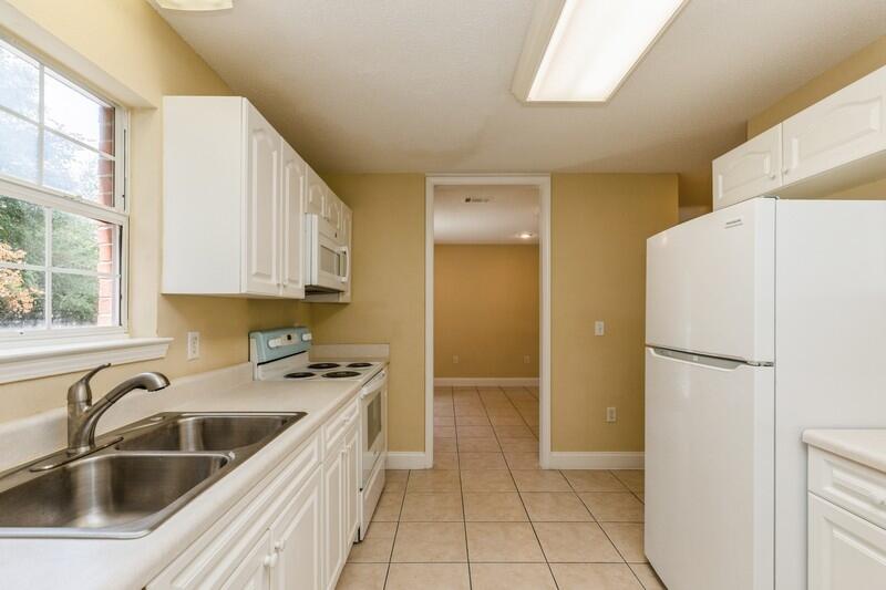 808 Valley Road Crestview, FL 32539 - Photo 13 of 35 a kitchen with a refrigerator sink and white cabinets