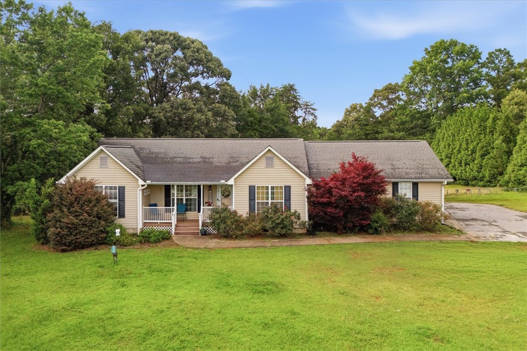 A welcoming front porch, shaded by mature trees, invites quiet moments.