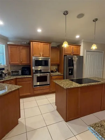 a kitchen with stainless steel appliances granite countertop a stove a sink a oven and a refrigerator