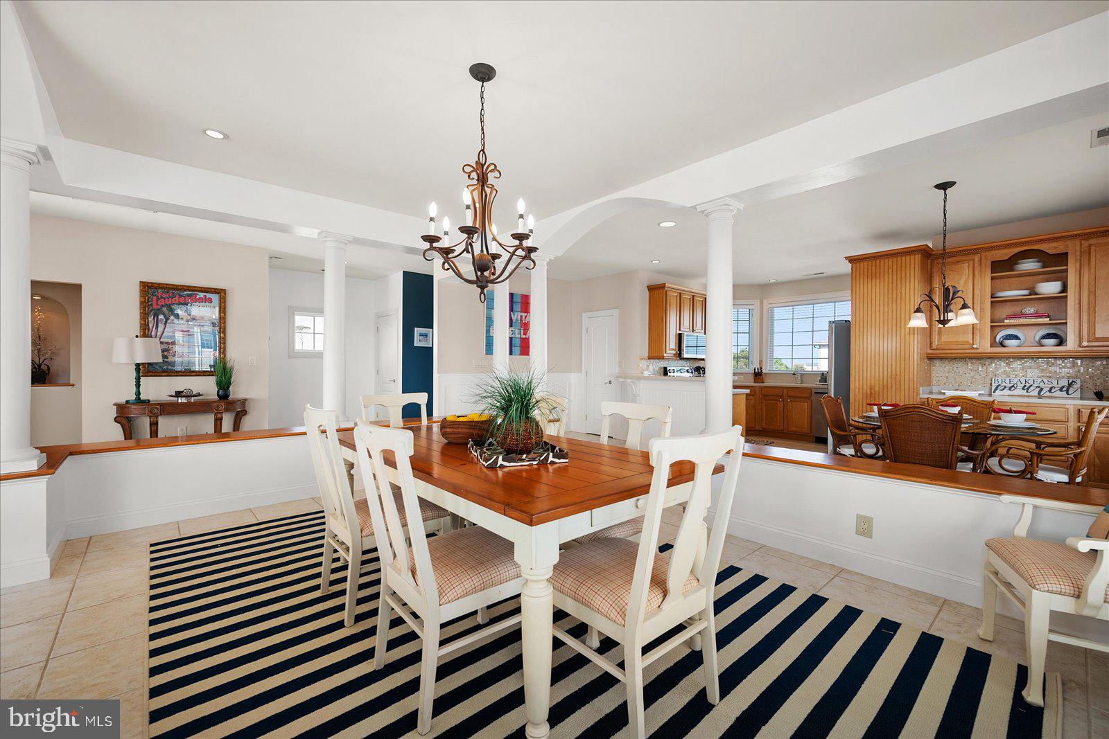 12901 Old Bridge Road, Unit PH8 2 Ocean City, MD 21842 - Photo 18 of 79 a dining room with wooden floor a chandelier a wooden table and chairs