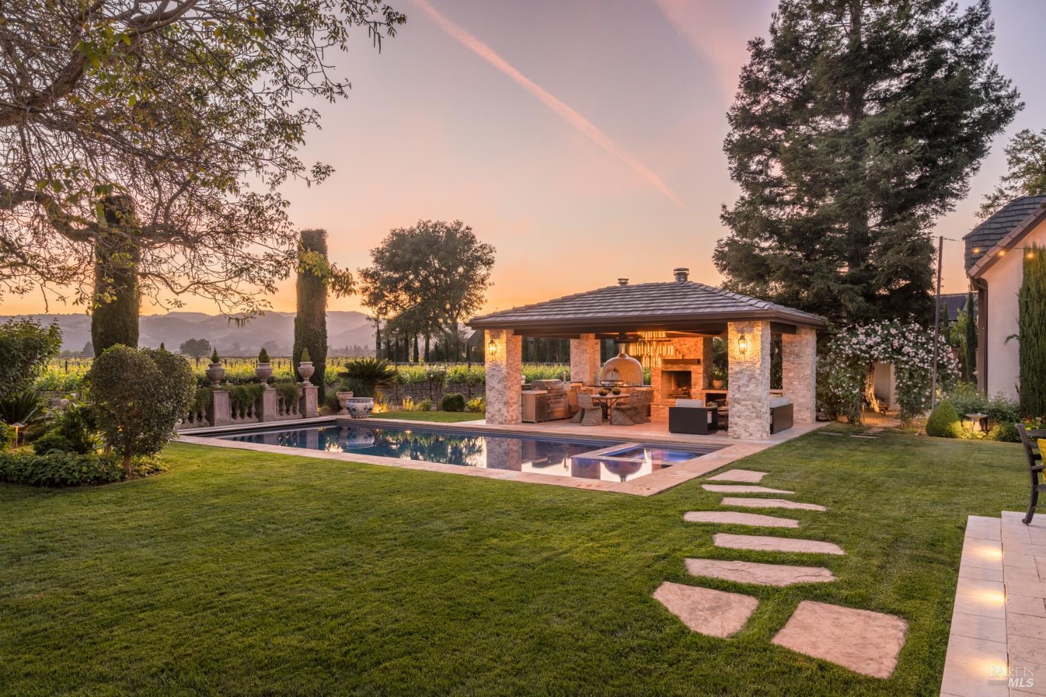a view of a house with a big yard potted plants and large tree