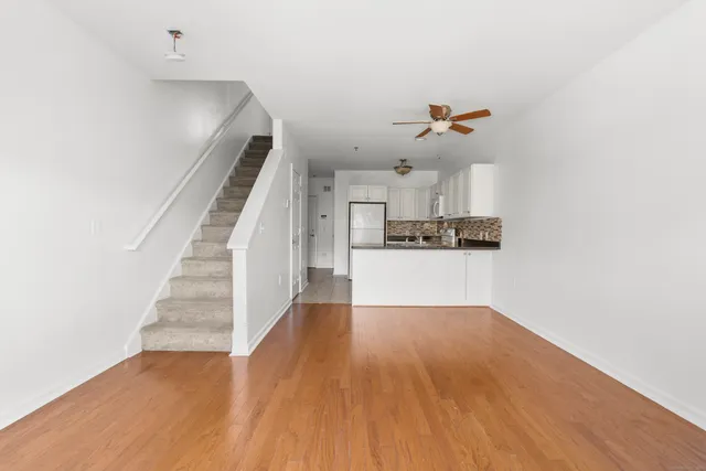 a view of a kitchen with wooden floor and a ceiling fan