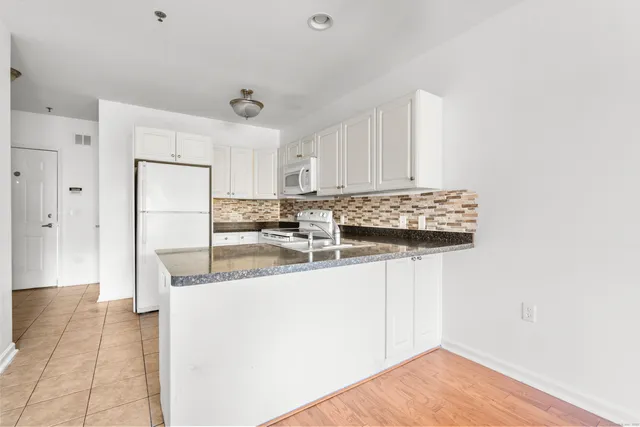 a kitchen with stainless steel appliances granite countertop a sink and a refrigerator