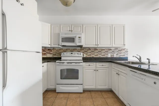 a kitchen with cabinets appliances a sink and a counter top space