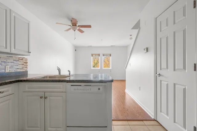 a kitchen with granite countertop a sink and cabinets