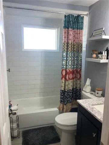 a bathroom with a granite countertop toilet a sink and a bathtub
