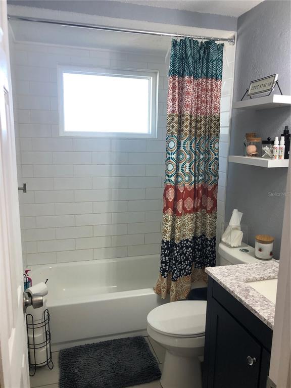 6425 Reno Avenue New Port Richey, FL 34653 - Photo 12 of 17 a bathroom with a granite countertop toilet a sink and a bathtub