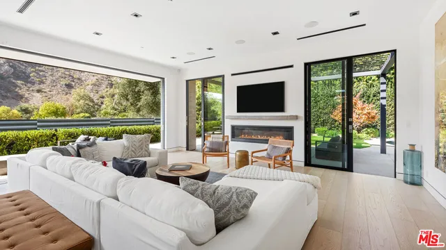 a living room with fireplace furniture large window and flat screen tv