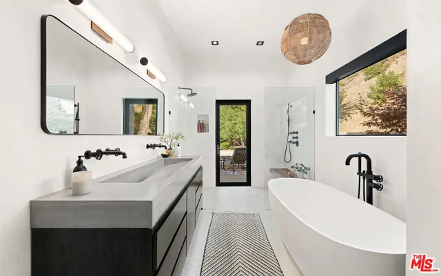 a bathroom with a double vanity sink mirror and bathtub