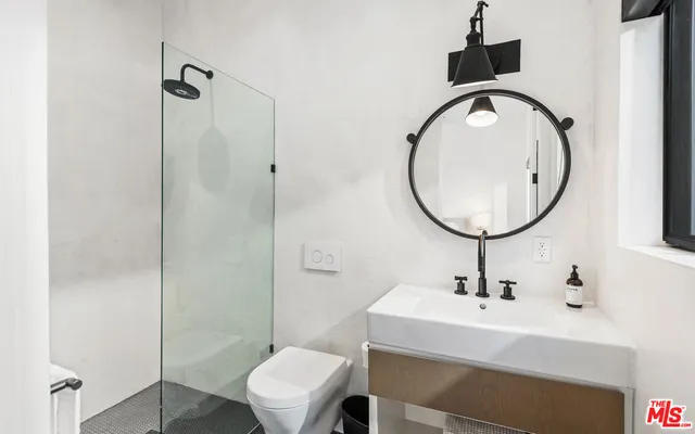 a bathroom with a sink a toilet and a mirror