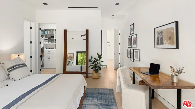 a bedroom with a bed and a potted plant