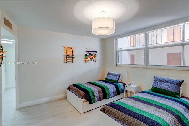 a bedroom with two beds and a large window