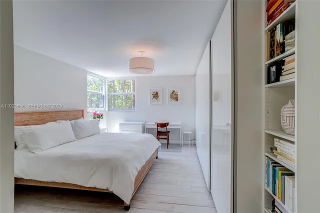 a bedroom with a bed and a large window